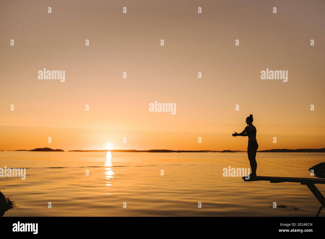 Silhouette of woman standing on springboard at sea Stock Photo - Alamy