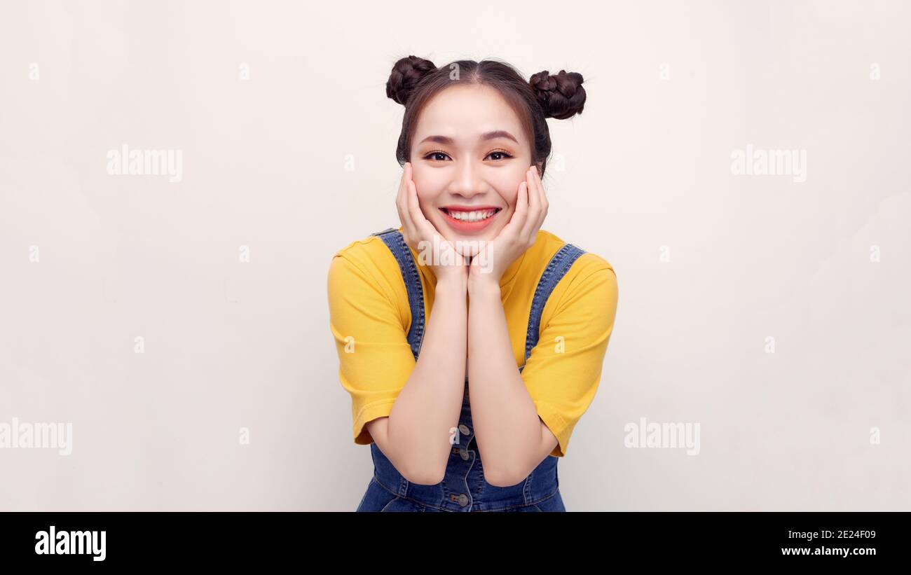 Naughty black-haired lady with bright makeup winks and smiles on white background Stock Photo