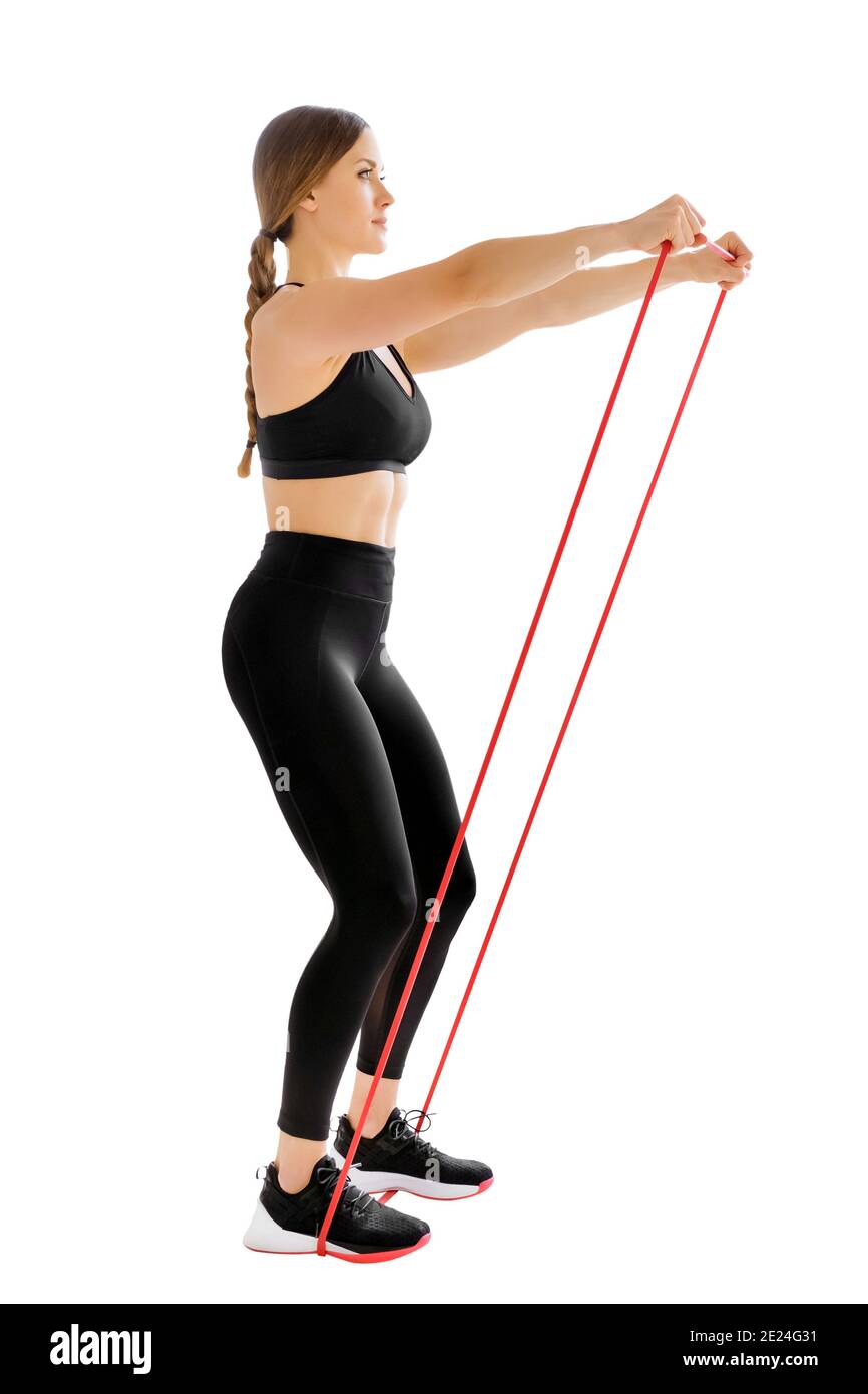 Woman athlete training with a power band doing a frontal rise exercise to strengthen her muscles isolated on white in a health and fitness concept Stock Photo