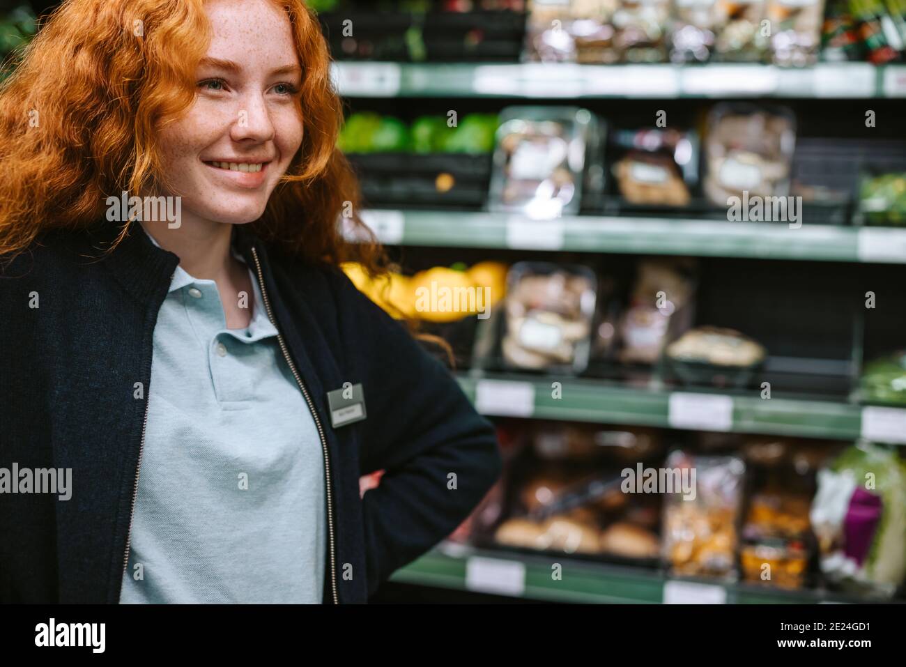 Woman working in a local grocery store. Woman on a holiday job at supermarket. Stock Photo