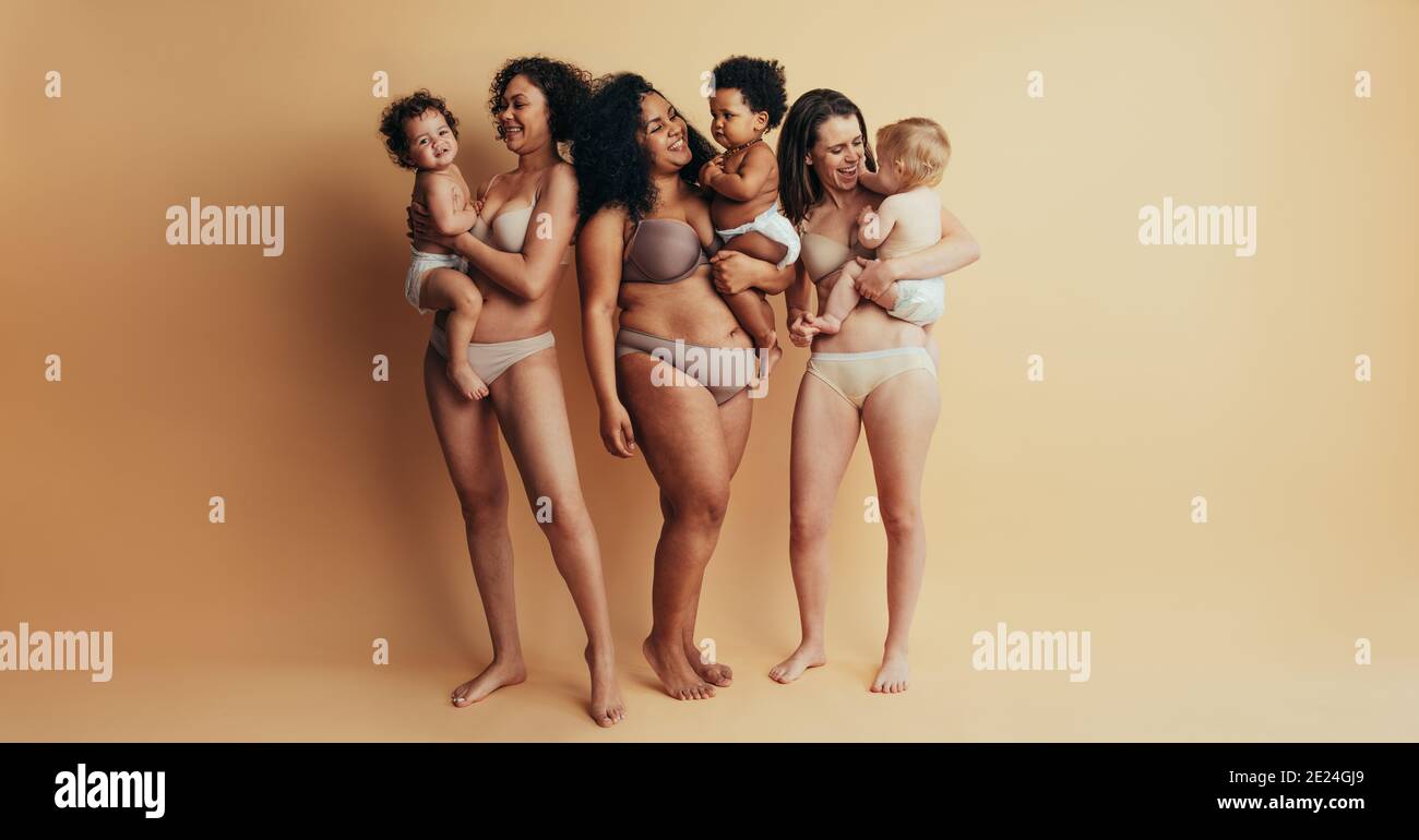 Full length of group of mothers with babies on mothers day. Mommies support group. Smiling moms and children expressing happiness and love. Stock Photo