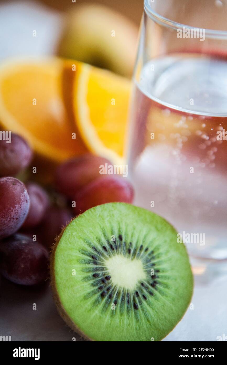 Kiwi fruit next to glass of water Stock Photo