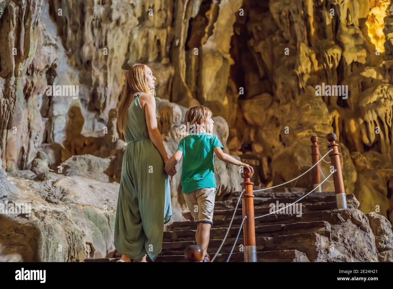 Mom and son tourists in Hang Sung Sot Grotto Cave of Surprises, Halong Bay, Vietnam. Traveling with children concept. Tourism after coronavirus Stock Photo