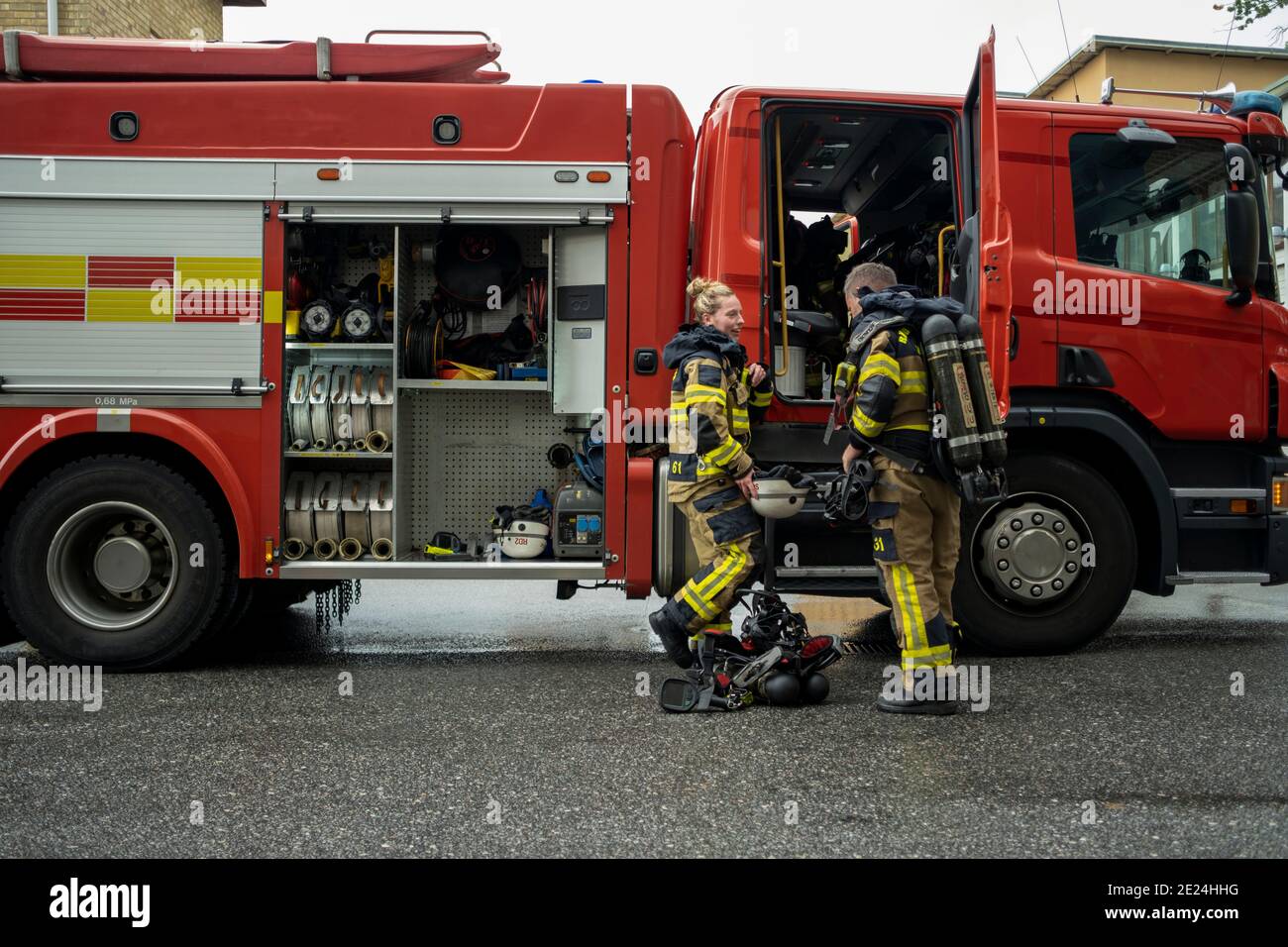 Firefighters in front of fire engine Stock Photo
