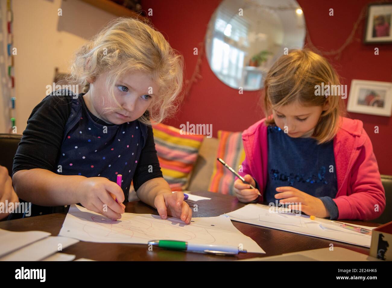 Girls of 3 and 5 years old doing school work  at home during the Covid school closure. Stock Photo