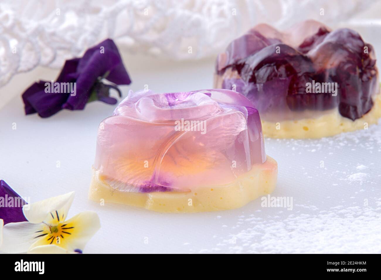 Unique japanese dessert Havaro of jelly and bavarian cream with edible violet flowers. Gelatin healthy eating dessert. Stock Photo