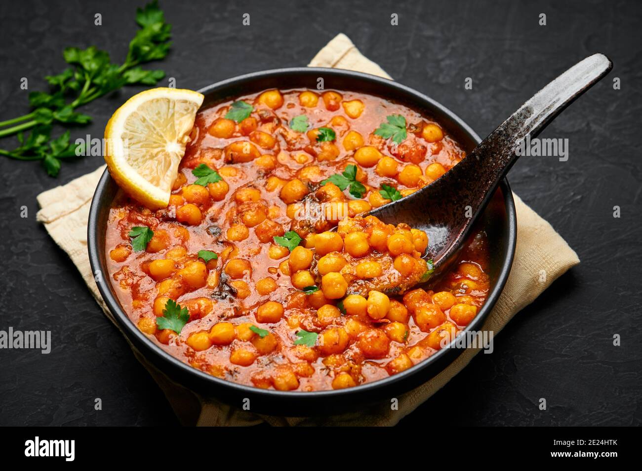 Chana Masala or Chole in black bowl on dark slate table top. Indian