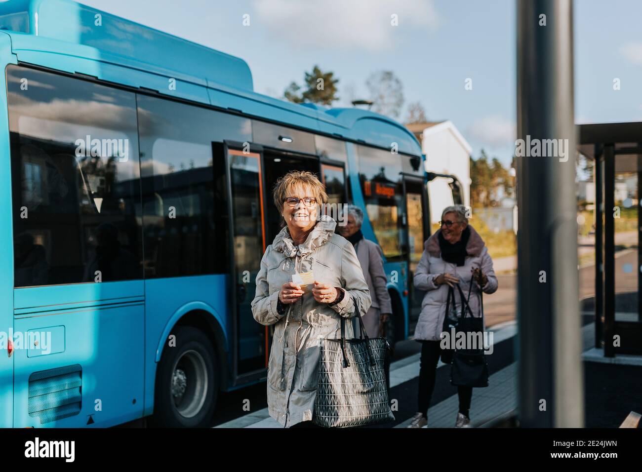 Smiling woman at bus station Stock Photo