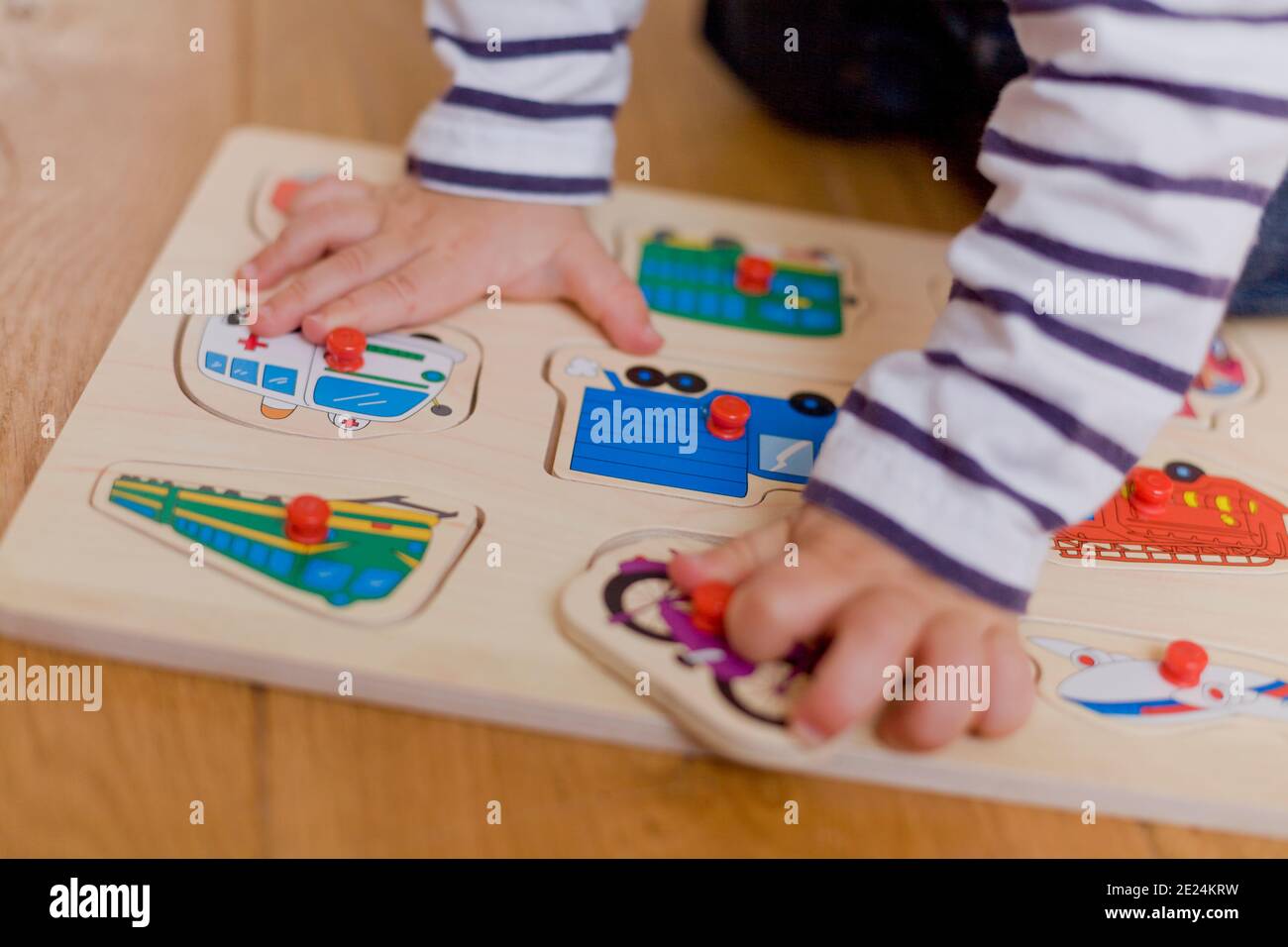 Toddlers hands holding peg puzzles Stock Photo Alamy