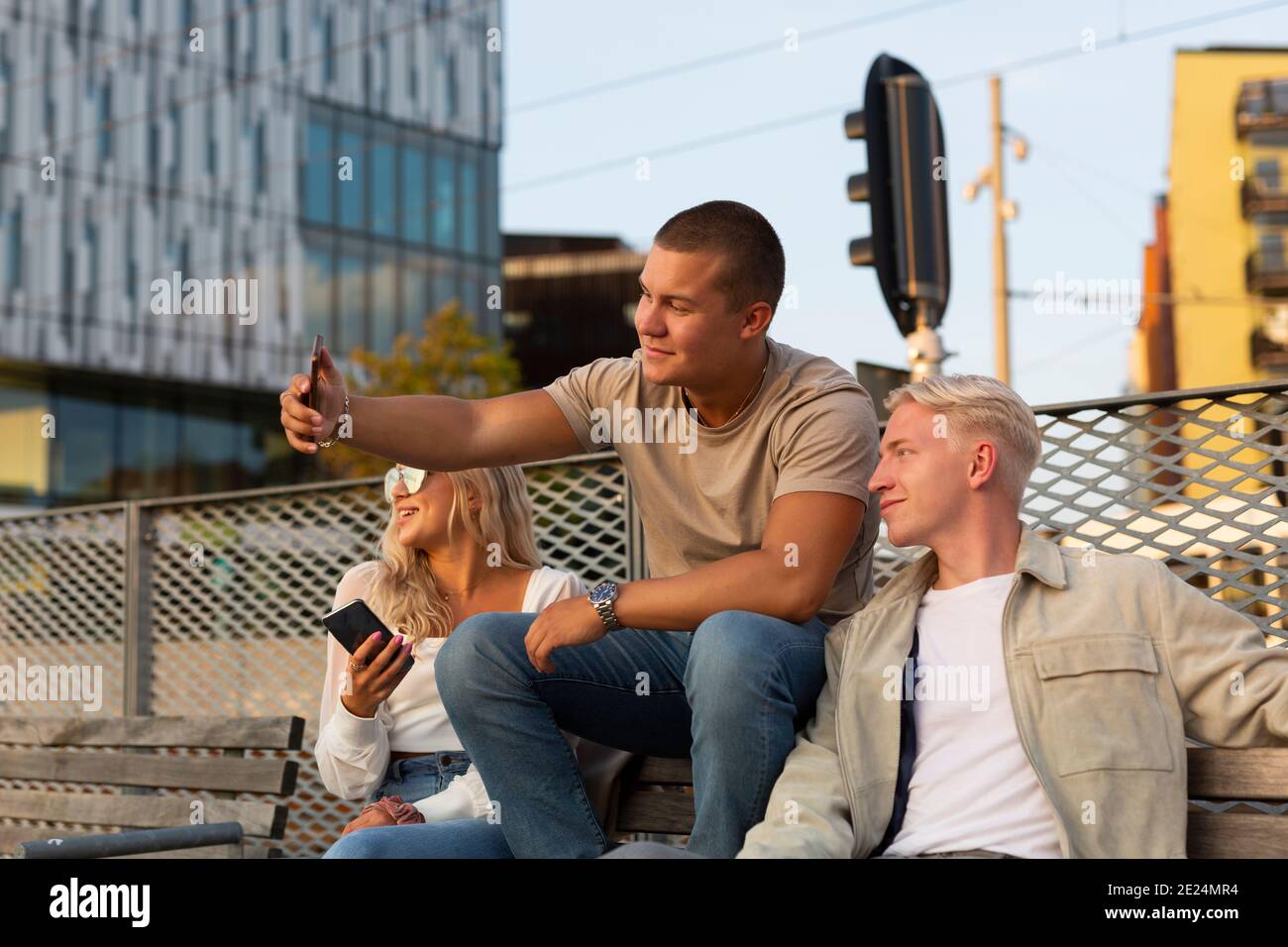 Friends on bench taking selfie Stock Photo