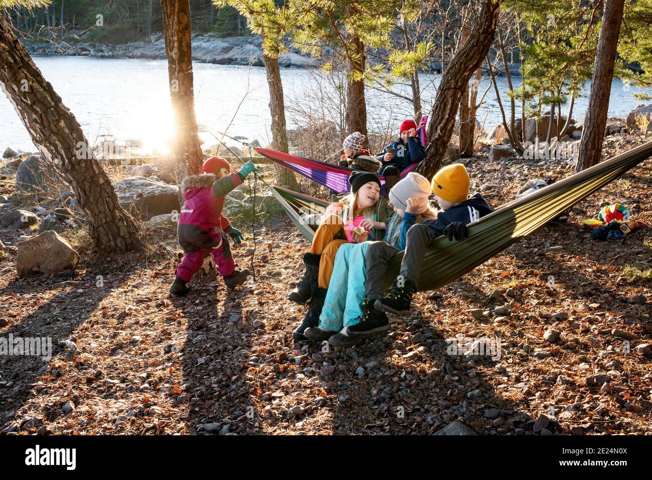 Children on hammocks by lake Stock Photo Alamy