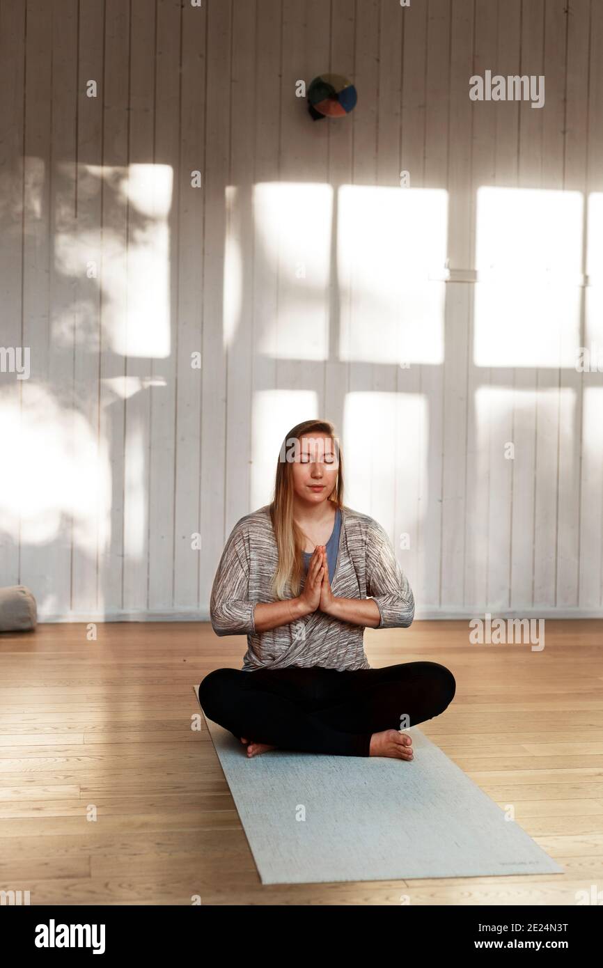 Woman practicing yoga in studio Stock Photo