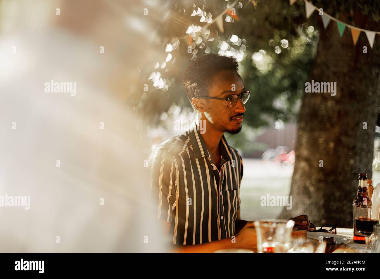 Man sitting at table in garden Stock Photo