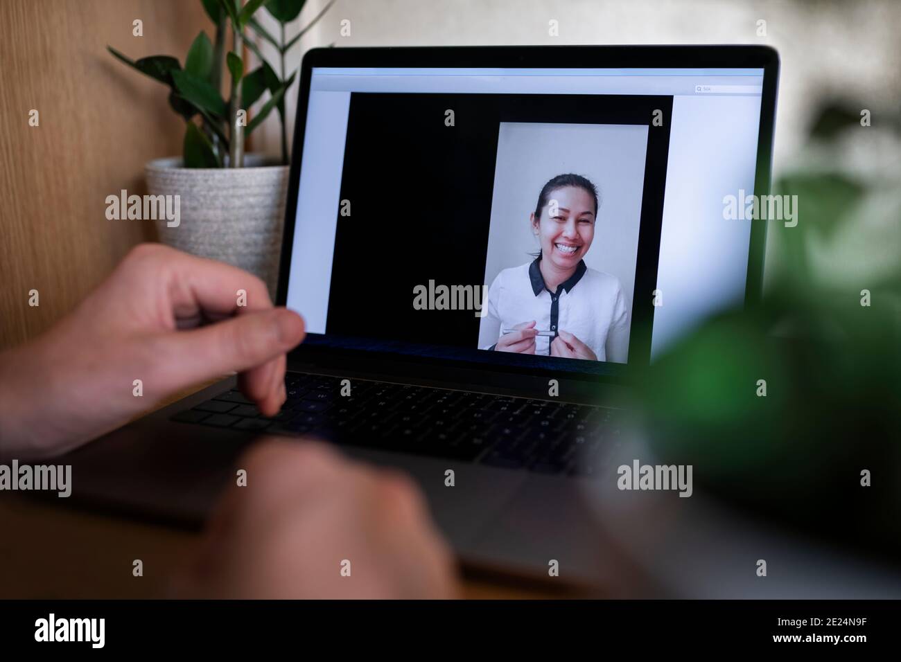 Smiling woman on laptop screen during video call Stock Photo
