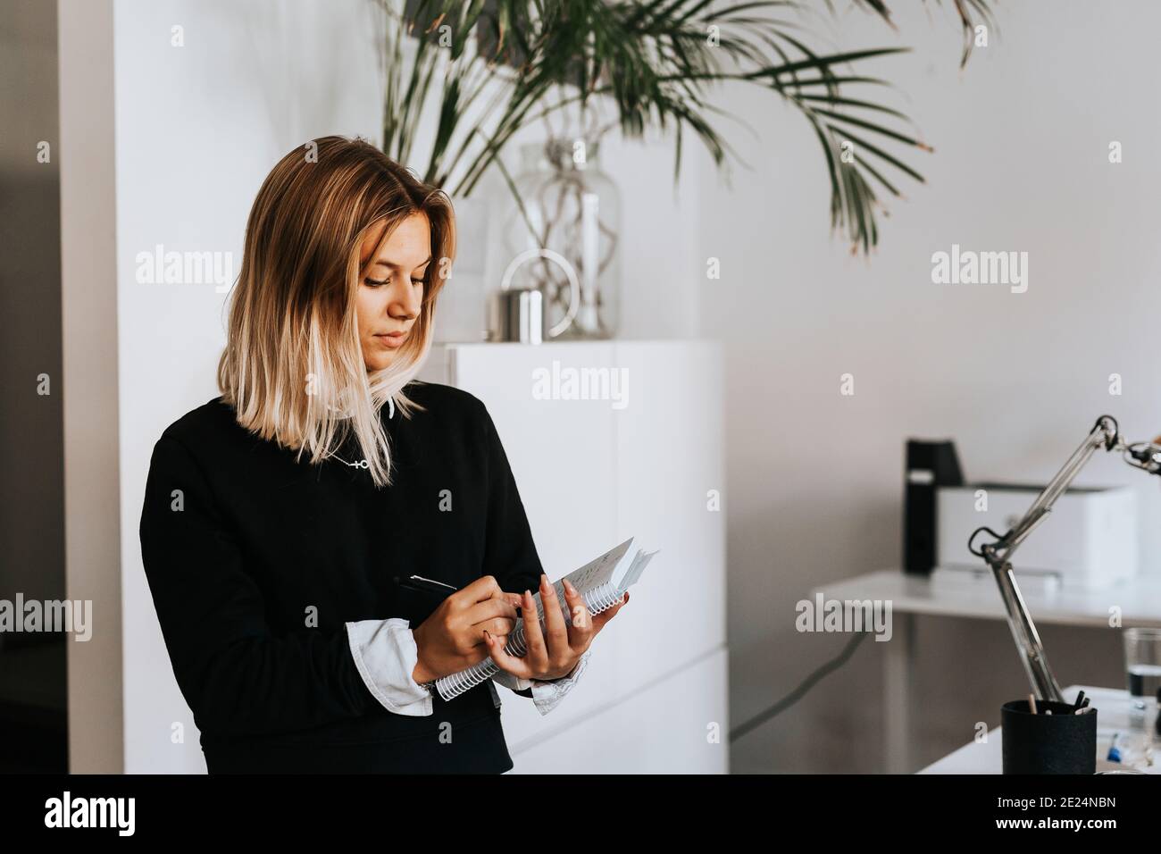 Woman taking notes in office Stock Photo
