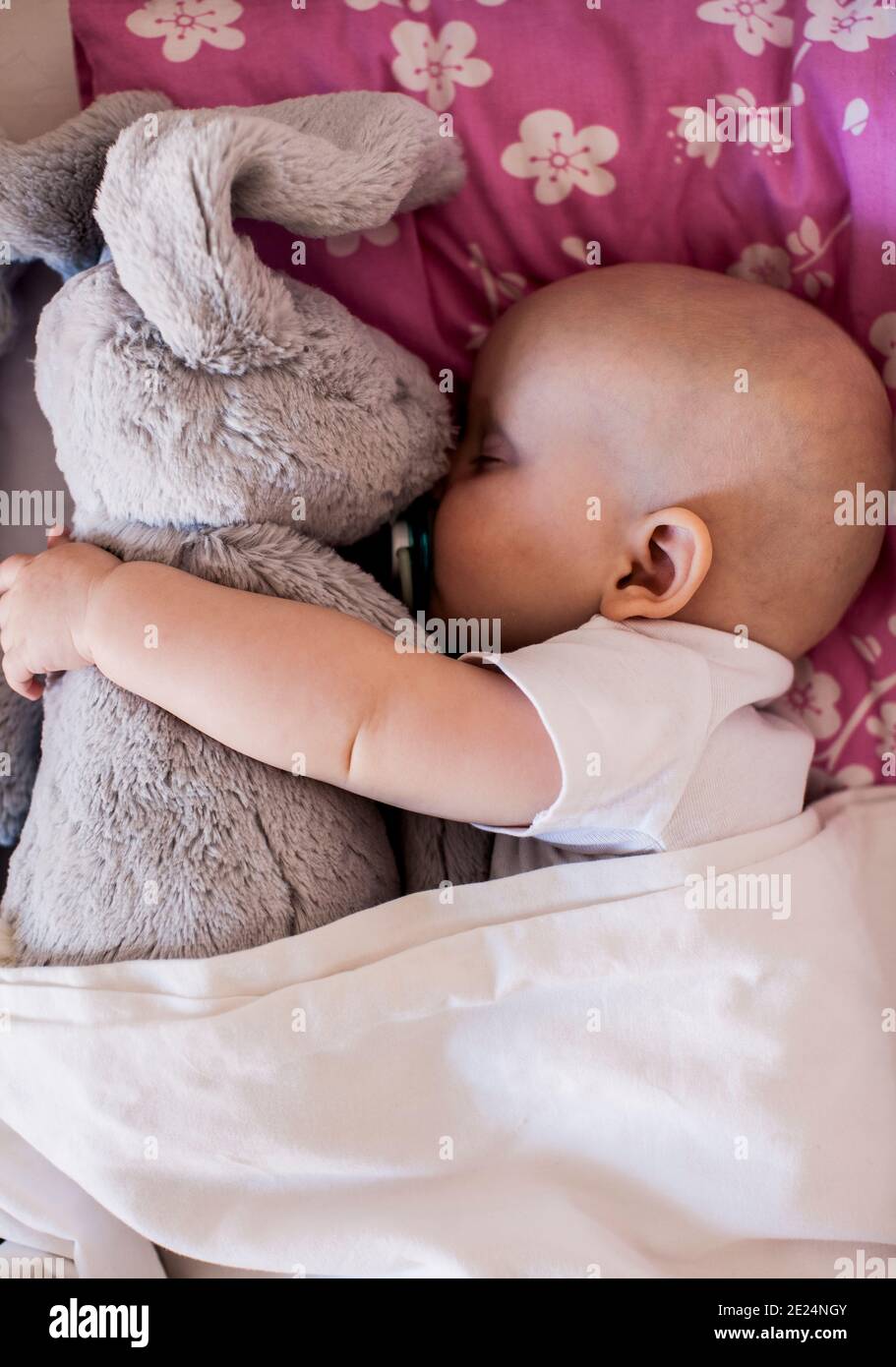 Baby sleeping with cuddly rabbit Stock Photo