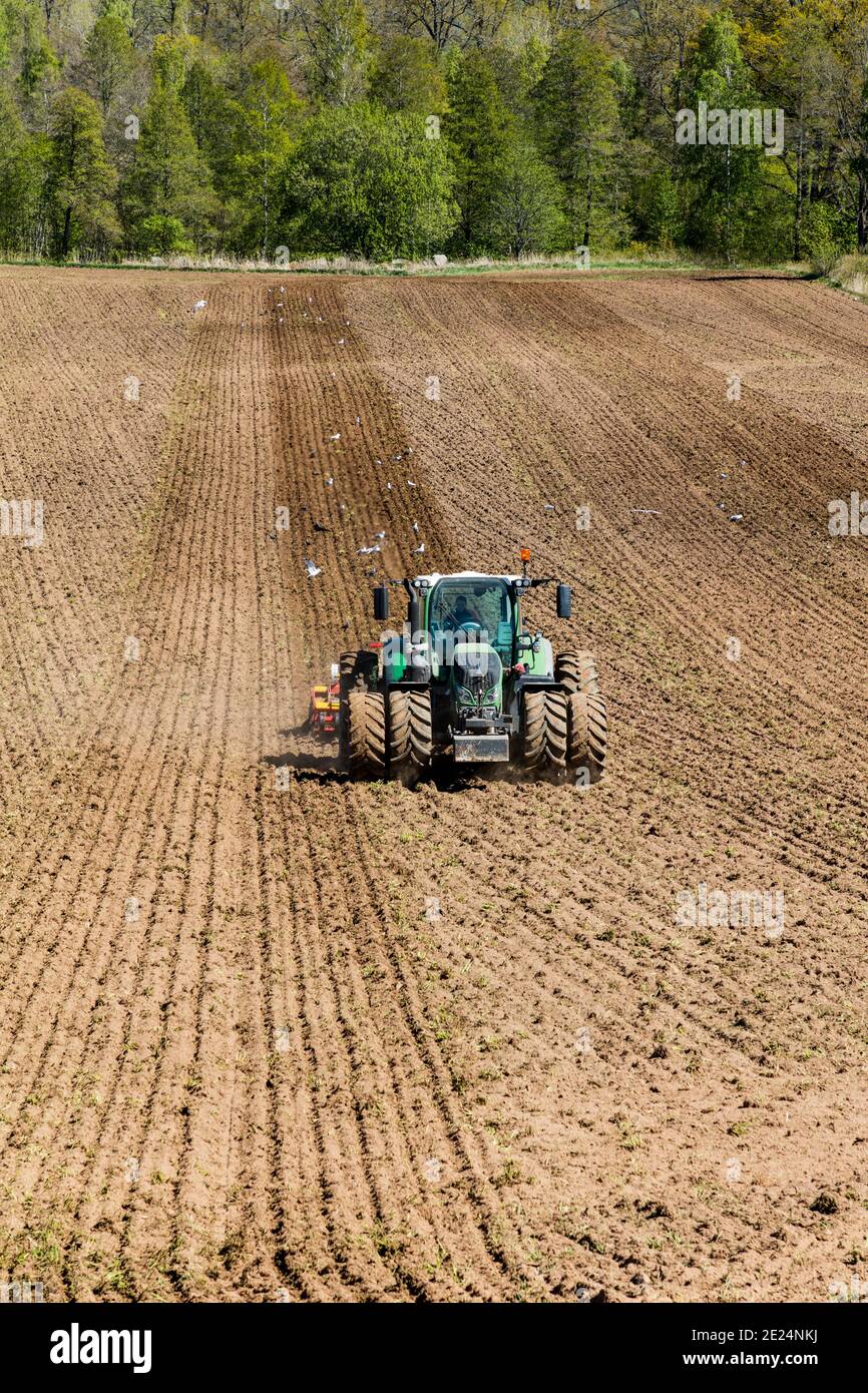 Tractor harrowing field Stock Photo - Alamy