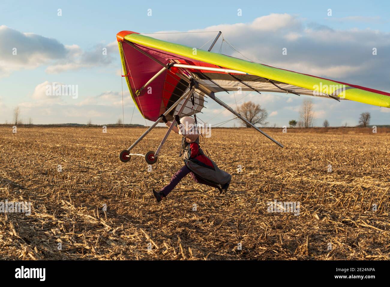 Learning to fly. Beginner student pilot runs fast with hang glider wing