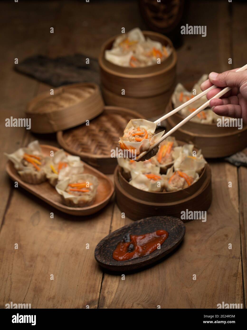 Person eating Shumai steamed Chinese dumplings with pork Stock Photo