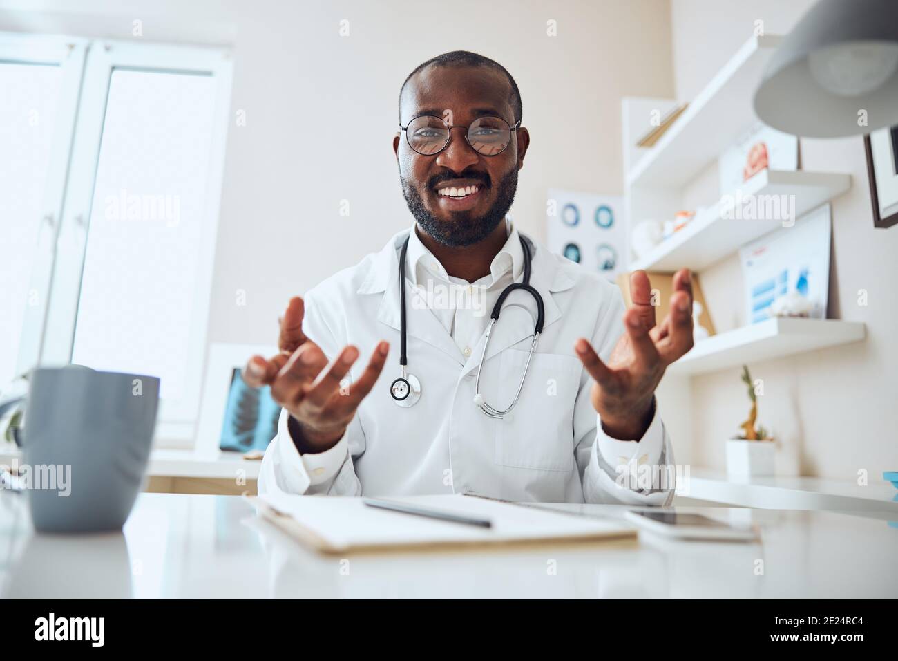 Excited Afro-American therapeutist explaining the patient test result Stock Photo