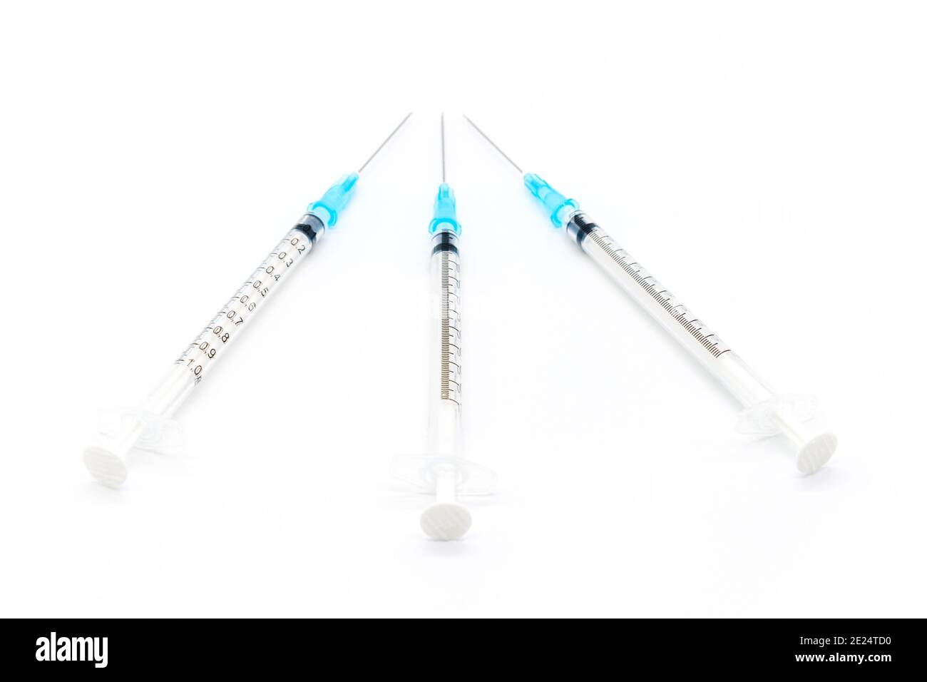 Medical syringes and needles for hypodermic injection on a marble counter top. The syringe and
