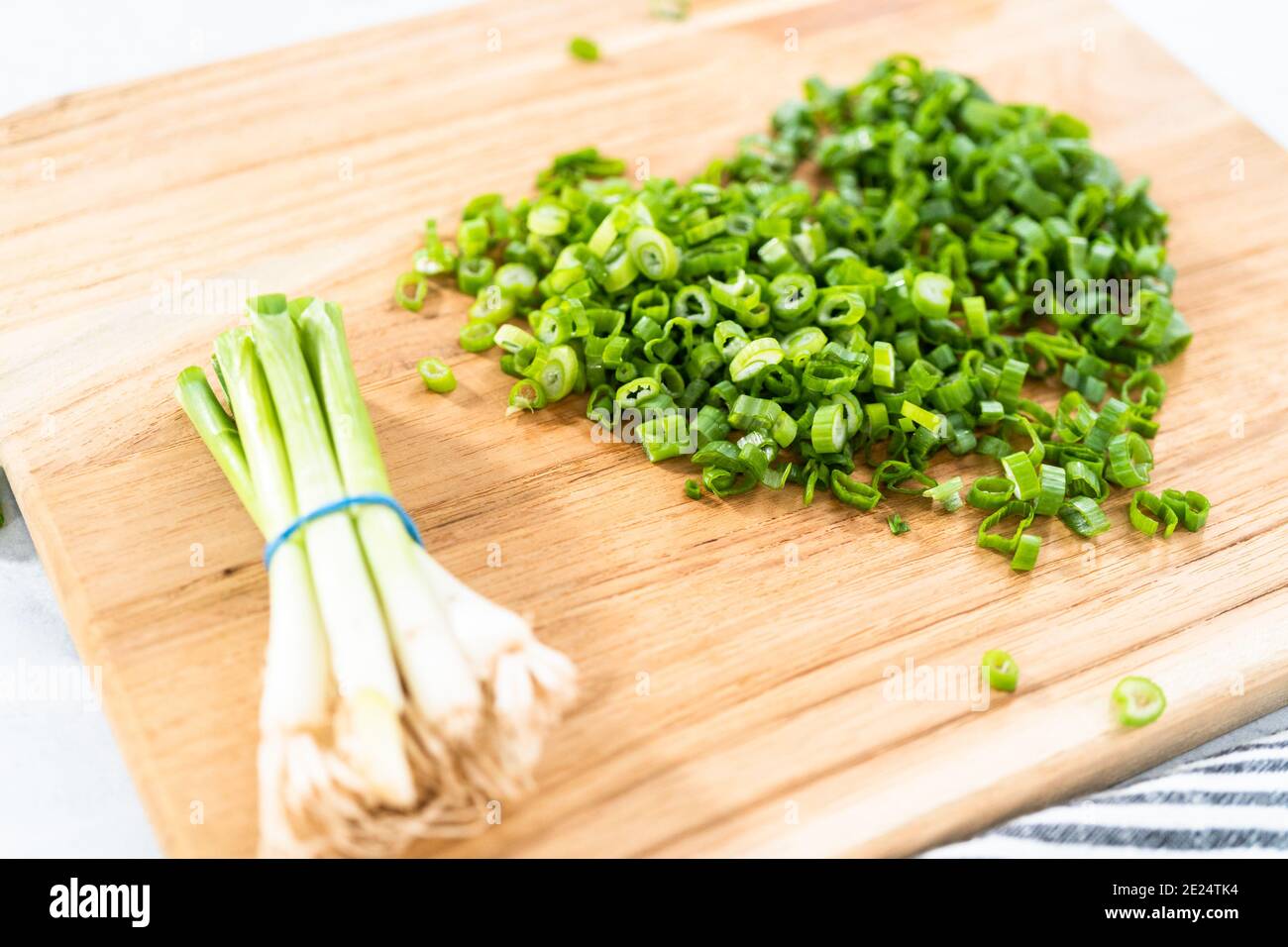 Chopping organic green onions on a wood cutting board Stock Photo - Alamy