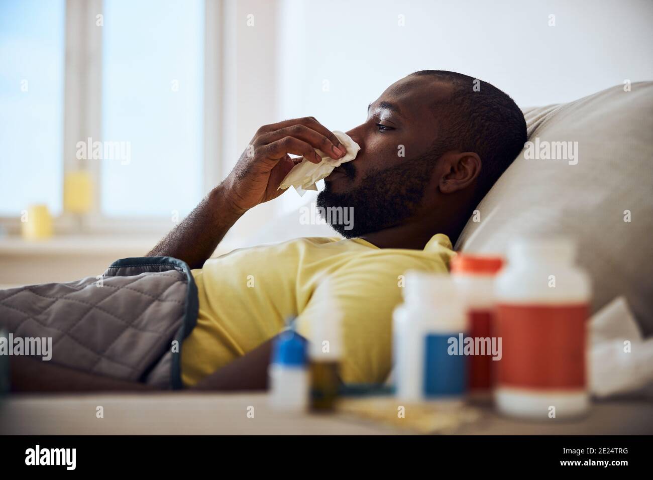 Mixedrace ill man is wiping his nose Stock Photo Alamy