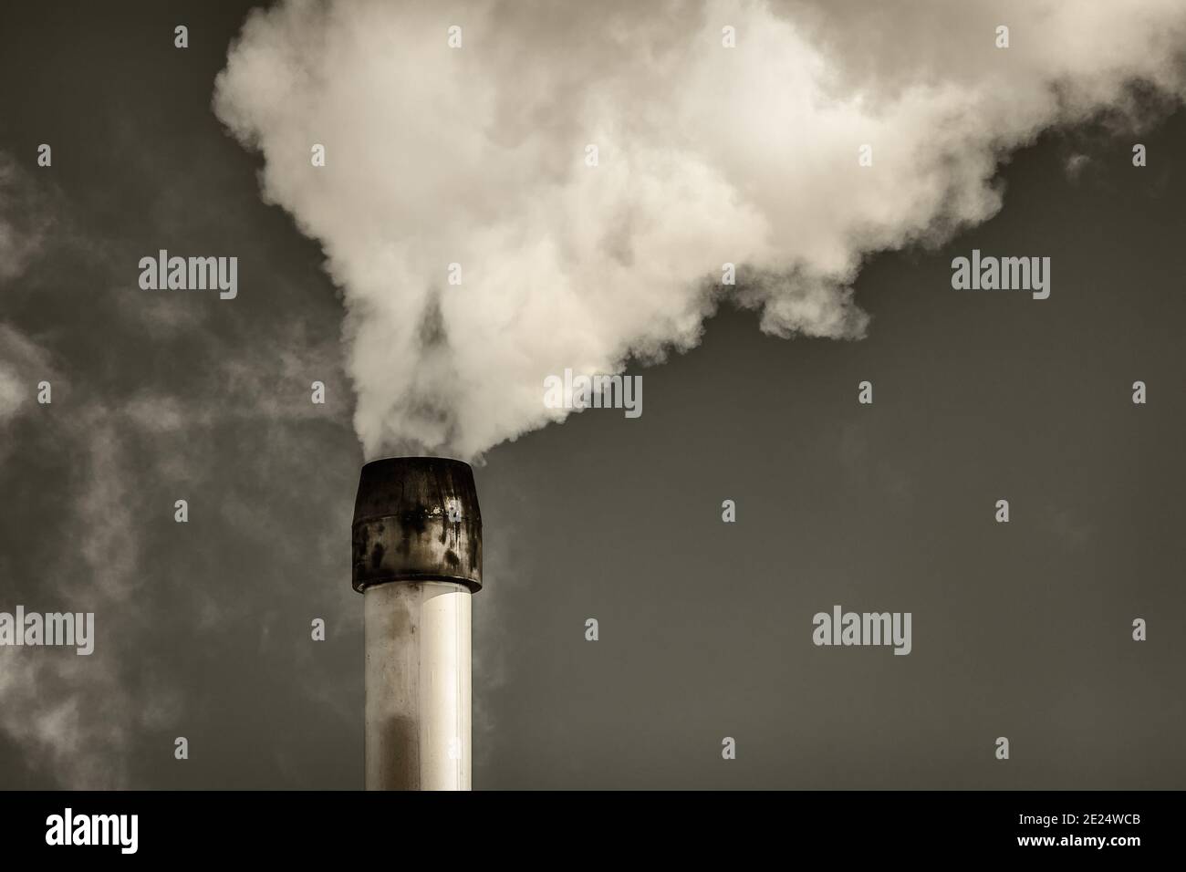Retro styled image of air pollution from a factory pipe Stock Photo