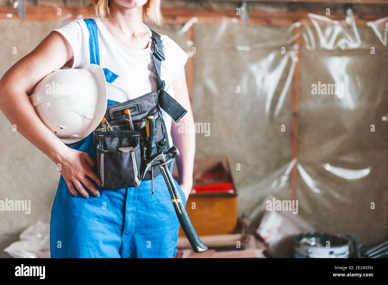 Woman builder in overalls with tools and hard hat Stock Photo