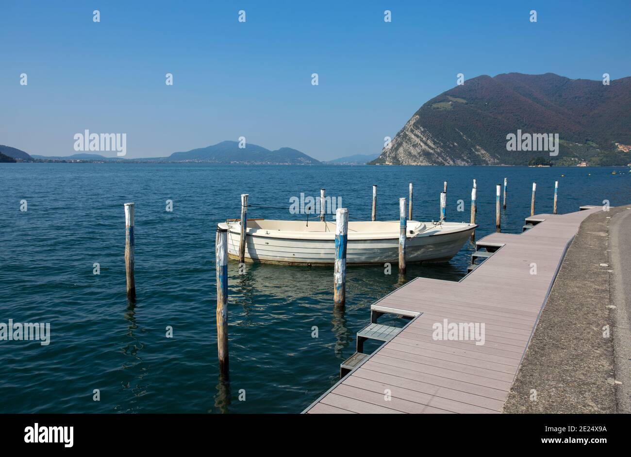 Isolated white boat moored at Monte Isola, Iseo Lake, Brescia province, Lombardy, Italy. Stock Photo