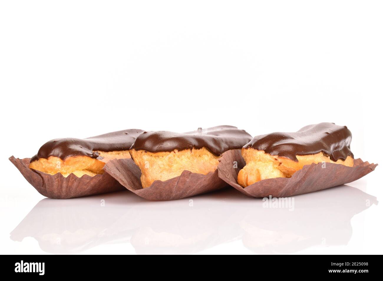 Three chocolate eclairs, close-up, isolated on white. Stock Photo