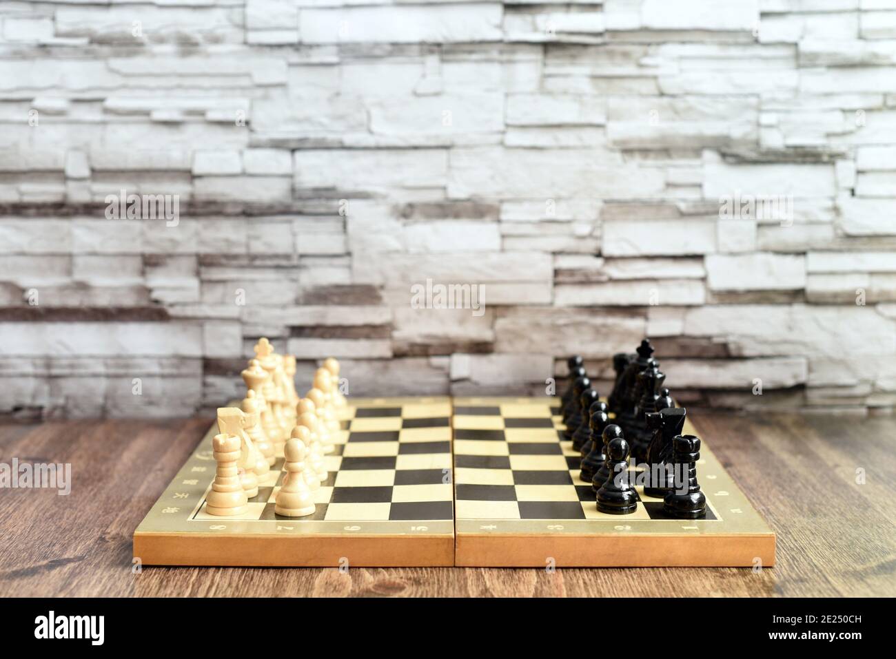 Chess pieces on chess board on wooden table. Blurred background with copy space Stock Photo