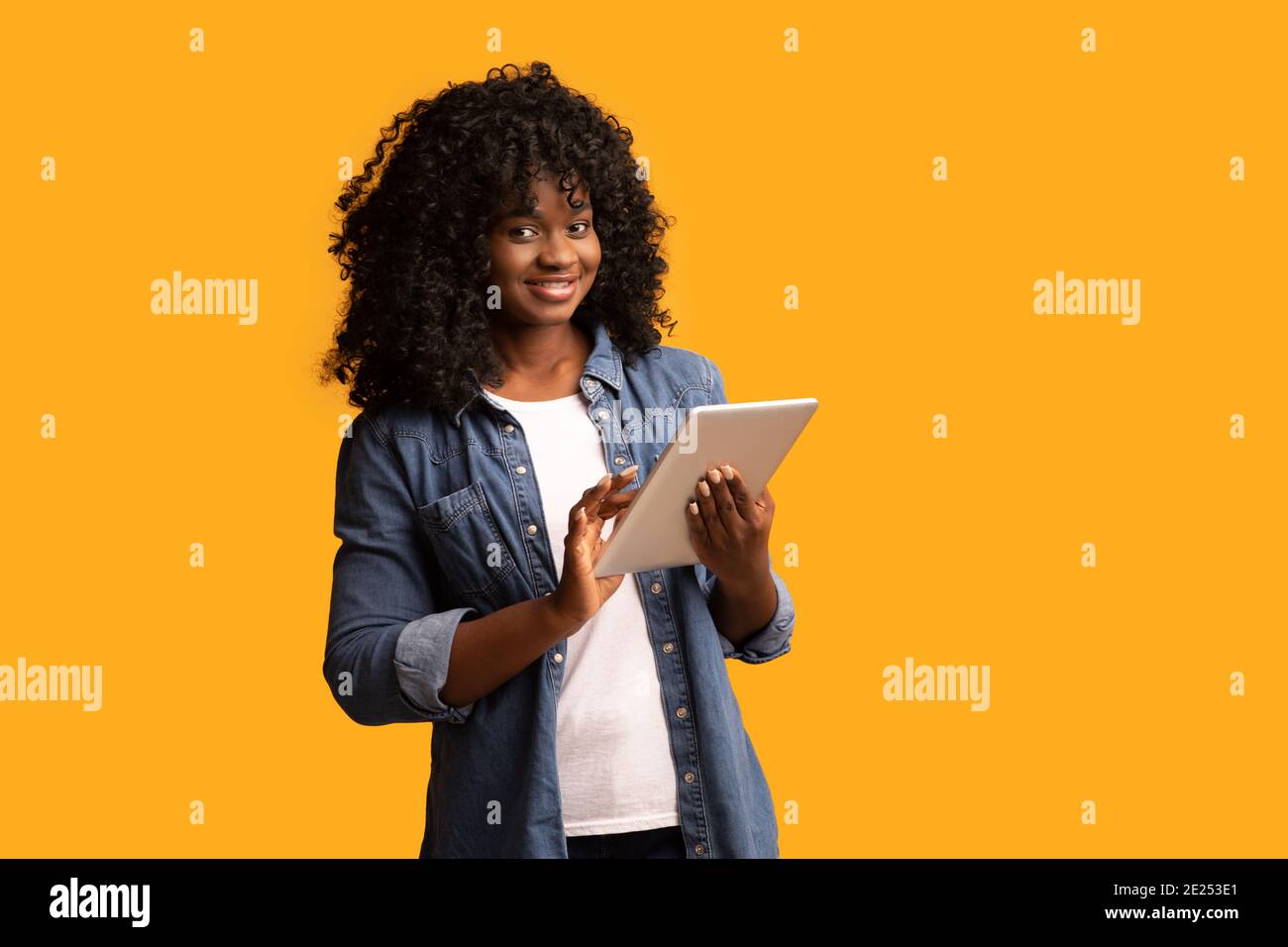 Cheerful beautiful black woman using digital tablet Stock Photo