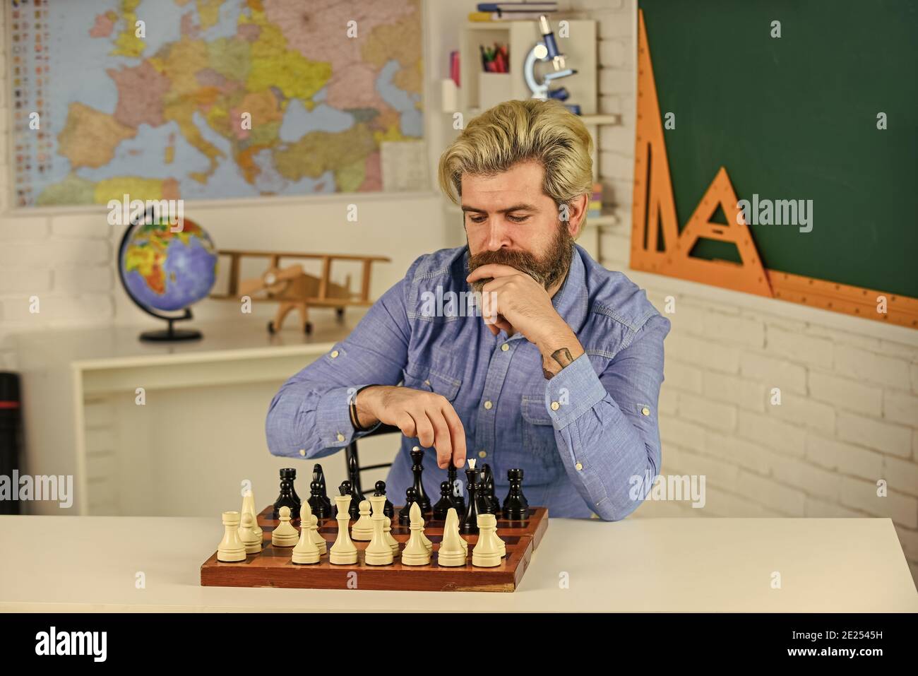 Chess is gymnasium of mind. Chess lesson. Strategy concept. School teacher.  Board game. Smart hipster man playing chess. Intellectual hobby. Figures on  wooden chess board. Thinking about next step Stock Photo -