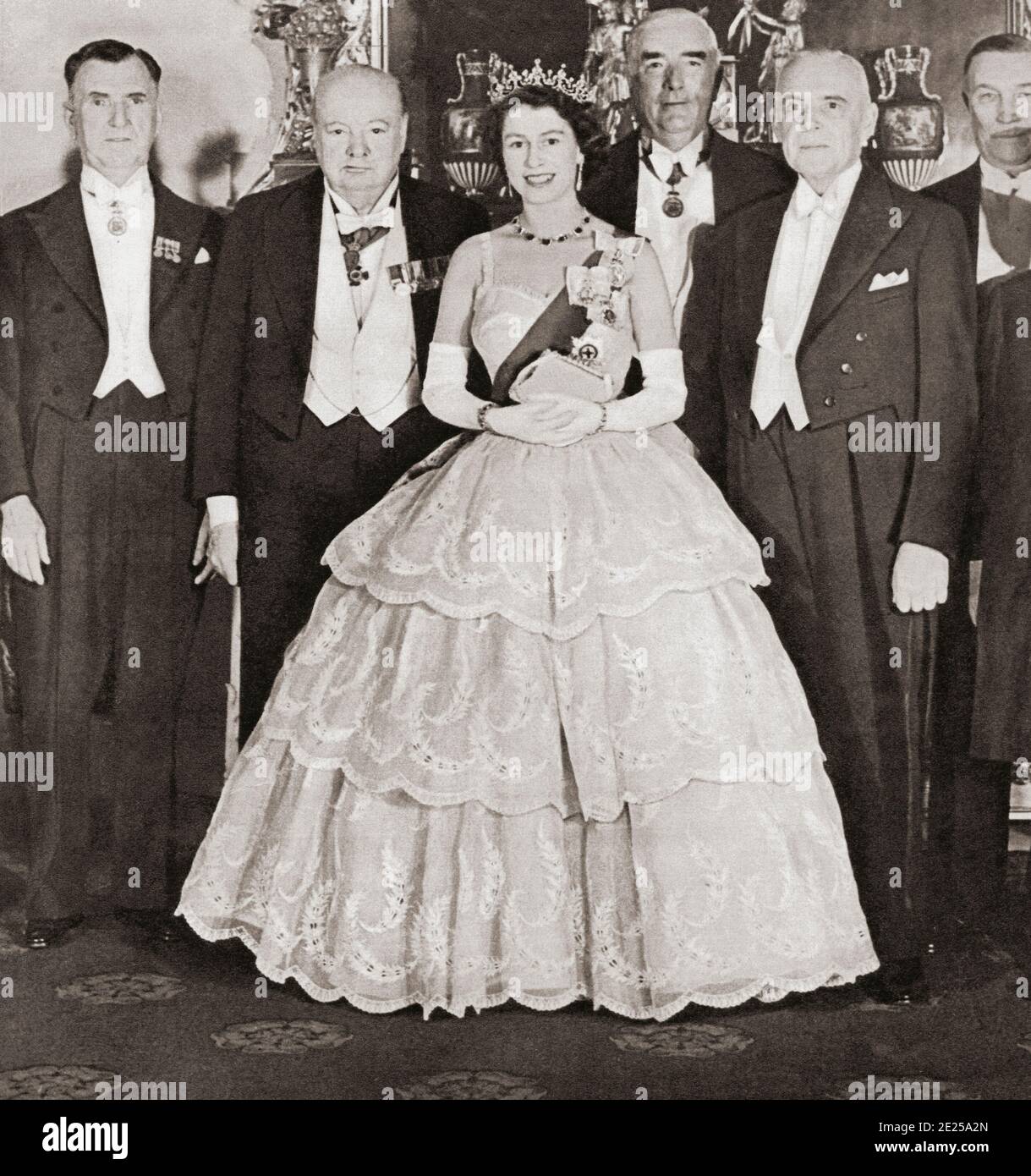 EDITORIAL ONLY Queen Elizabeth II entertaining the Prime Ministers of the Commonwealth at Buckingham Palace in 1952.  From left to right, Mr. S.G. Holland (New Zealand), Mr. Winston Chuchill (United Kingdom), Mr. Robert Menzies (Australia), and Mr. St. Laurent (Canada). From The Queen Elizabeth Coronation Book, published 1953. Stock Photo