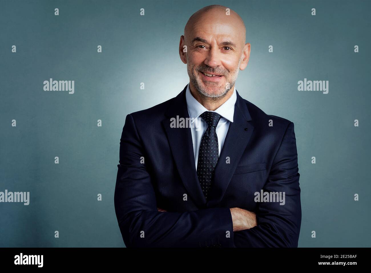 Studio portrait of confident businessman wearing suit while standing at ...