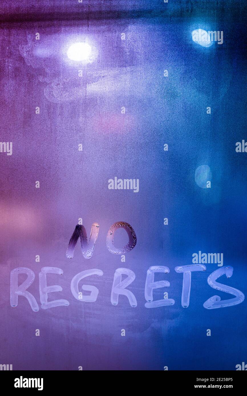 words no regrets hand written on purpleblue night foggy window glass