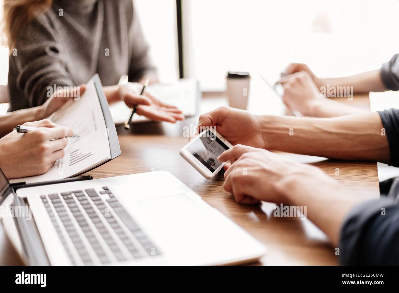 employee is using his smartphone to check the financial data. Stock Photo