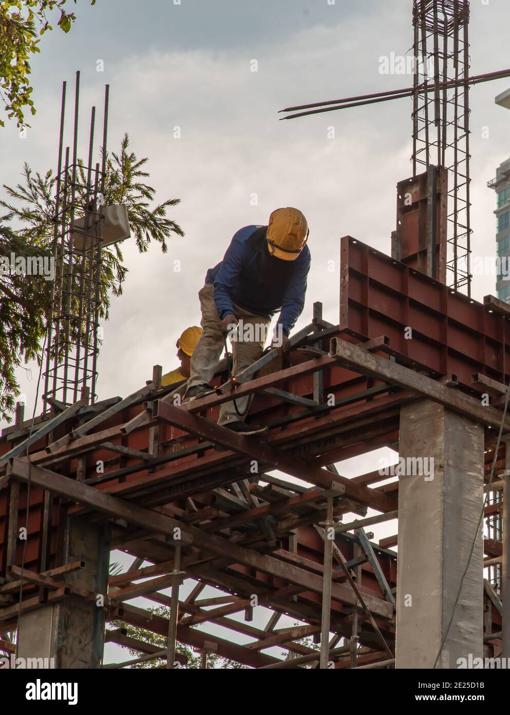 Construction Worker Welding soldering metal girders and Sparks in a