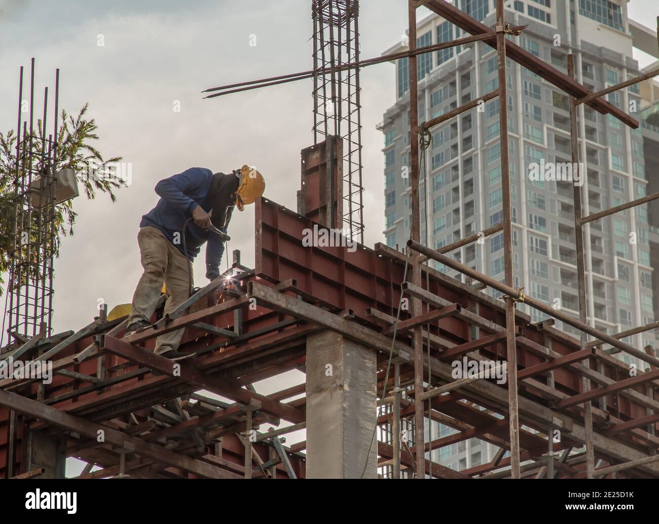 Construction Worker Welding soldering metal girders and Sparks in a