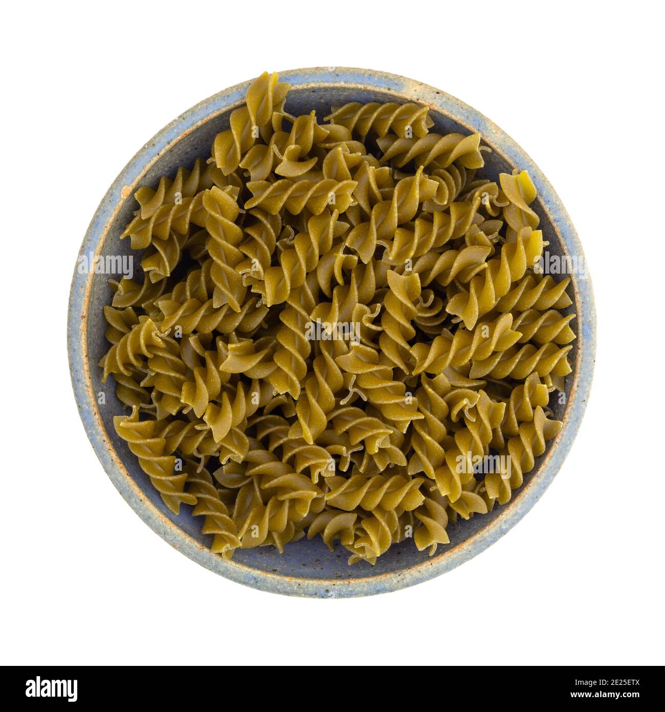 Top view of a serving of a serving of green pea fusilli in an old blue stoneware bowl isolated on a white background. Stock Photo