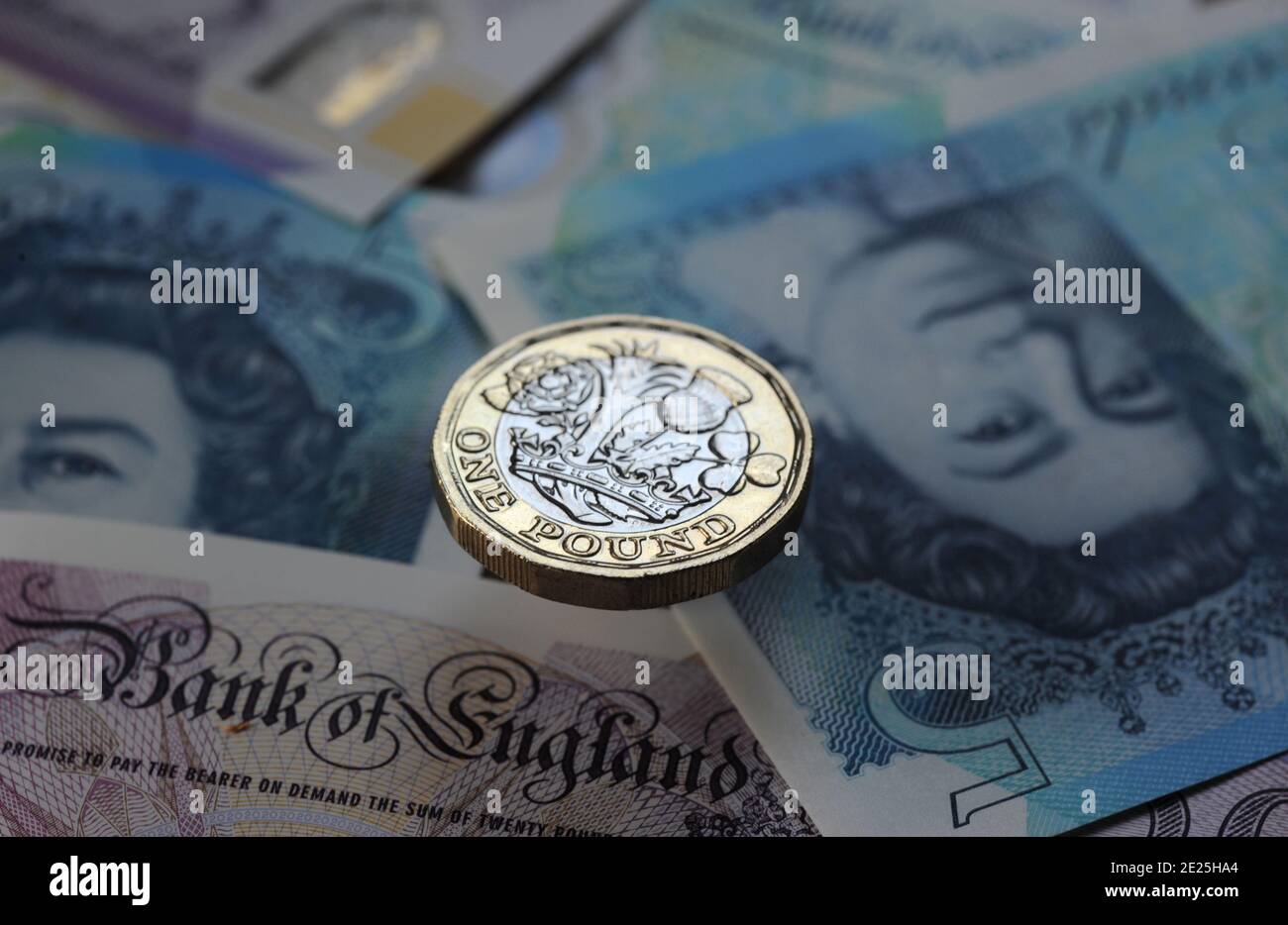 BRITISH ONE POUND COIN WITH CURRENCY NOTES RE BANKS INCOMES PENSIONS THE BANK OF ENGLAND ETC UK Stock Photo