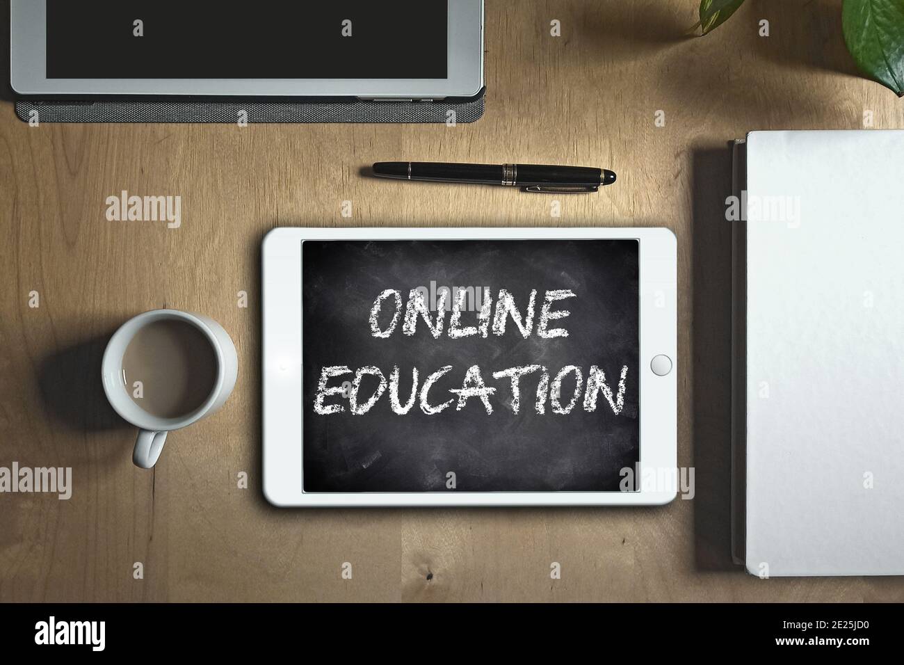 Student's desk at home assisting to an online class using a tablet. Online education concept. Stock Photo