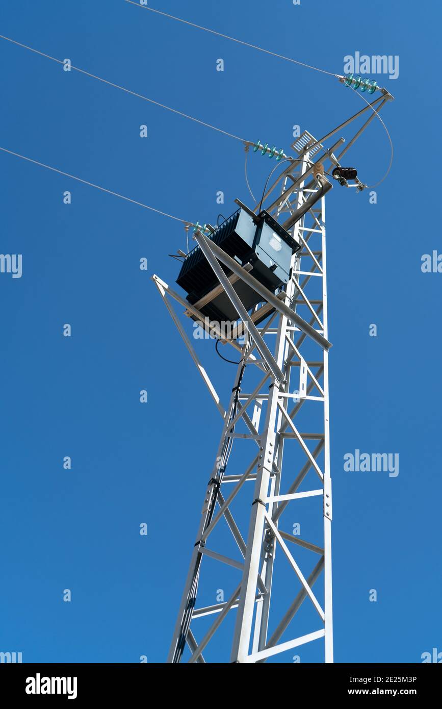 Power pole for electricity transmission and distribution in front of blue sky Stock Photo