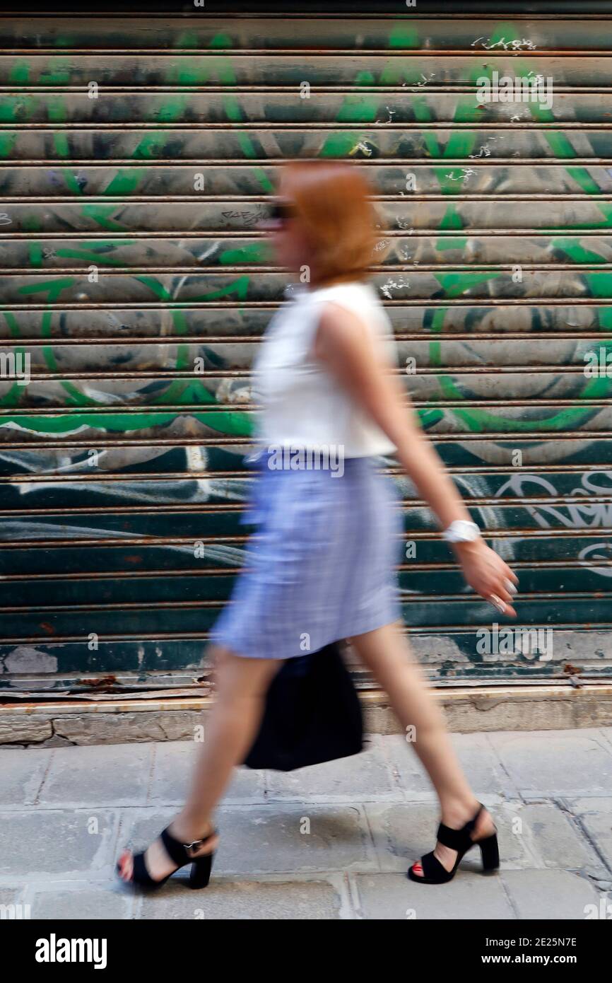 Woman walking by painted wall. Stock Photo