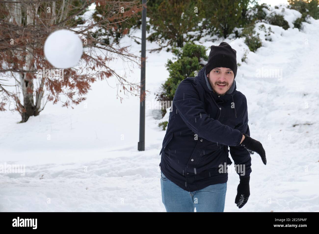 Young caucasian man throwing a snowball in a park during Filomena snowstorm  in Madrid, Spain. Winter activities Stock Photo - Alamy