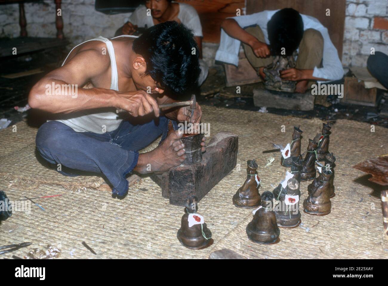 Nepali artisans cleaning up figurines produced by the process of lost wax metal casting of statues and figurines in Nepal Stock Photo
