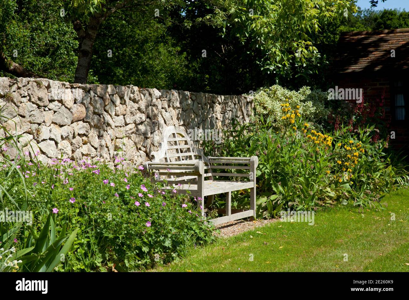 Lutyens bench against stone wall in garden Stock Photo