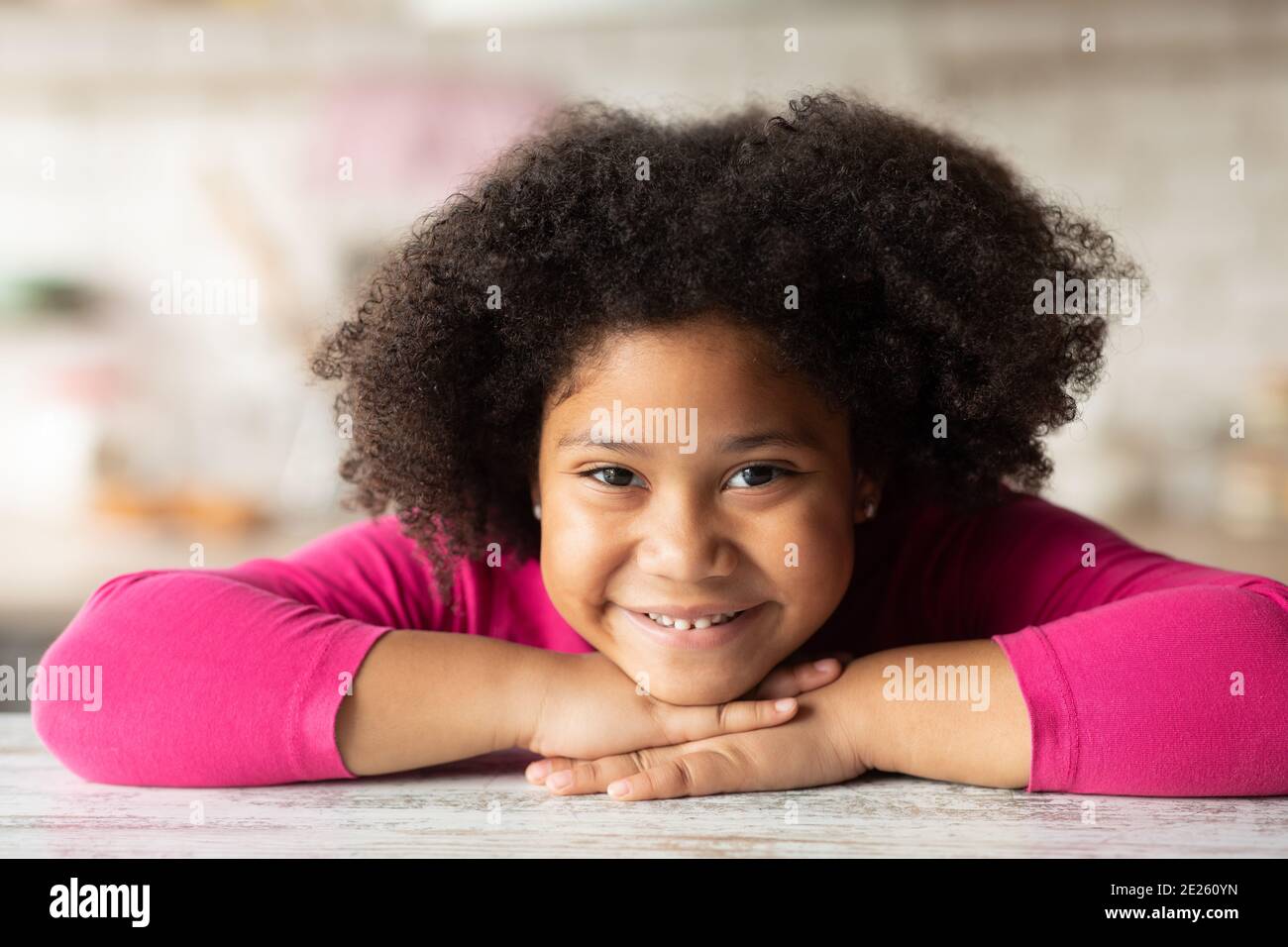 close-up portrait of cute surprised african child girl in blue t-shirt  looking up at something interesting, girl having curly fluffy hair, smiling  hap Stock Photo - Alamy