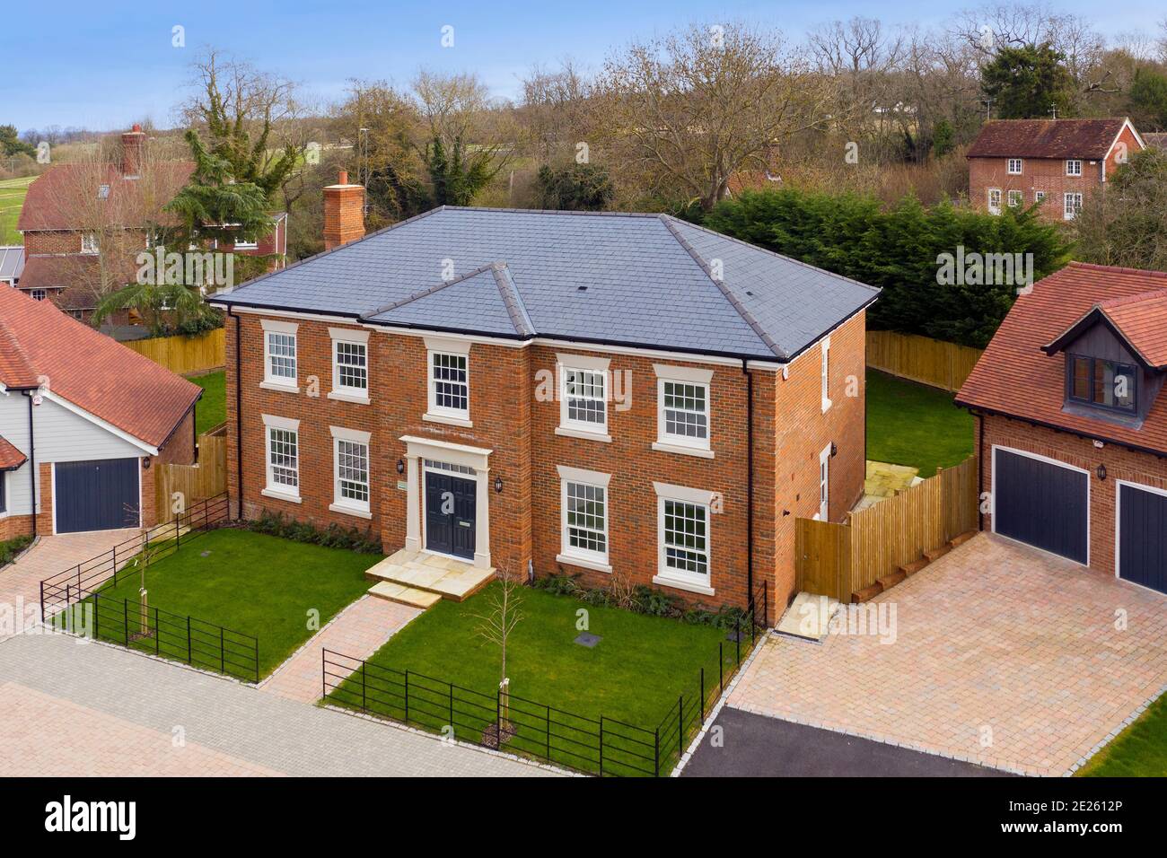 Drone shot of Georgian style new build house with double garage block on small estate Stock Photo